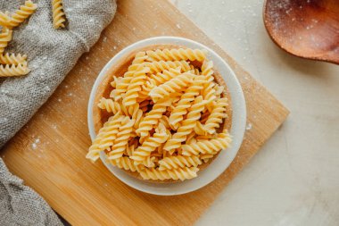 Spiral tortiglionili makarna. Parlak mutfakta. Buğdaydan yapılmış ev yapımı makarna. Akdeniz yemekleri pişirmek. yiyecek içeriği, seçici odak