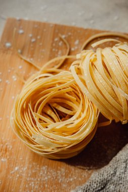 Parlak mutfakta ev yapımı Pappardelle çiğ makarna. El yapımı buğdaydan makarna yapma süreci. Evde Akdeniz yemekleri var. seçici odak