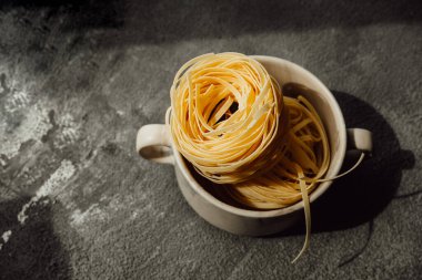 Karanlık mutfakta ev yapımı çiğ erişte. El yapımı buğdaydan makarna yapma süreci. Yemek blogu. seçici odak
