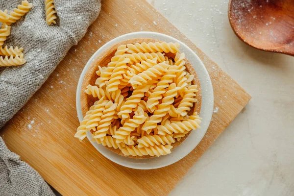 Spiral tortiglionili makarna. Parlak mutfakta. Buğdaydan yapılmış ev yapımı makarna. Akdeniz yemekleri pişirmek. yiyecek içeriği, seçici odak