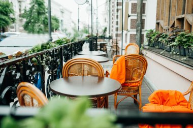Açık hava kafe terasında hasır ahşap mobilyalar, portakal meyveleri ve dekorasyon için yeşil bitkiler. Restoranların yaz terasları. seçici odak