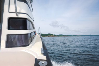 Yeşil dağların yaz manzarasına karşı mavi denizdeki en saf tekne. Gemideki maceralar. seyahat içeriği. seçici odak