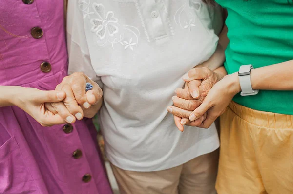 異なる年齢の女性の手が互いにしっかりと握っています 古いしわの女性の手 家族の絆が強い 女性の力 選択的焦点 — ストック写真