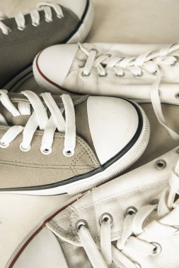 Beyaz ve yeşil iki çift lastik tabanlı hafif betona beyaz bağcıklı eski püskü spor ayakkabı. Gençlik kıyafeti. tekrar kullanılabilir. İkinci el kıyafetler. Üst Manzara. seçici odak