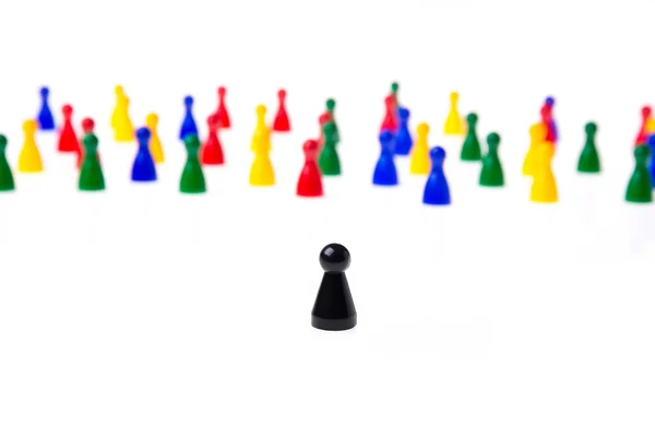 Mehrere Spielfiguren in verschiedenen Farben auf weißem Hintergrund. — Stockfoto