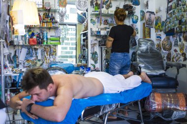 Dövme sanatçısı Tatto istemciye, Tayland yapıyor