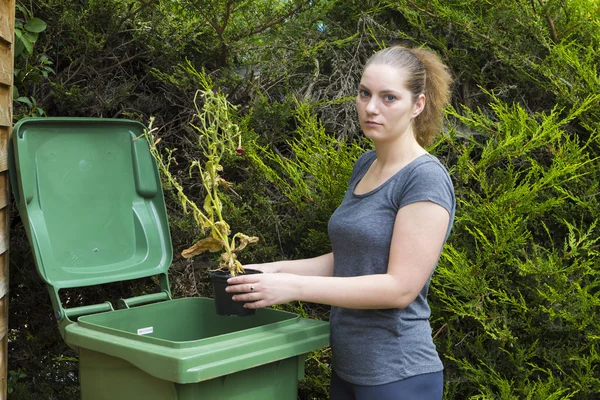 Девушка возле контейнера для садовых отходов — стоковое фото