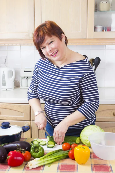 Домохозяйка среднего возраста готовит овощи — стоковое фото