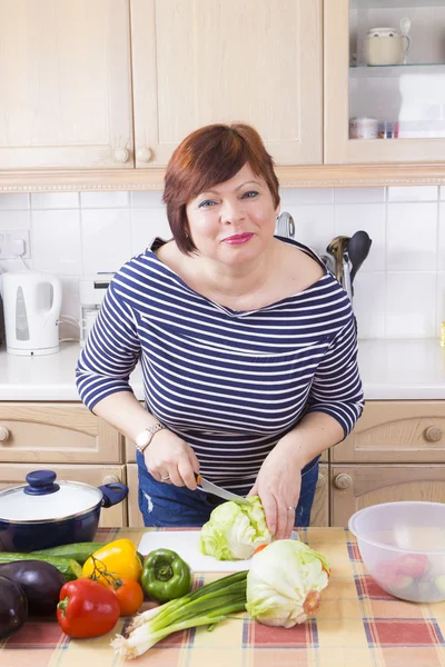 Edad media ama de casa cocinar verduras — Foto de Stock