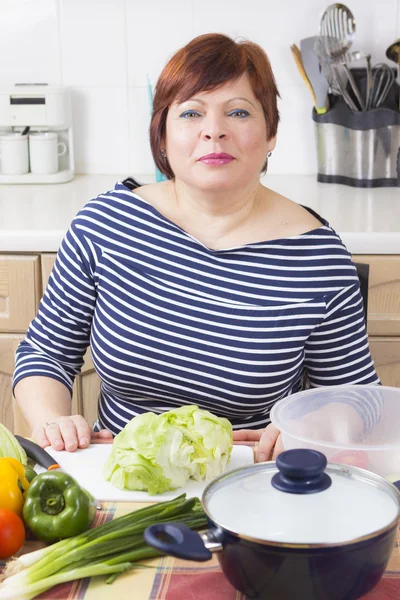 Edad media ama de casa cocinar verduras —  Fotos de Stock