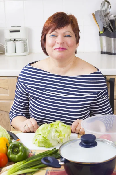 Edad media ama de casa cocinar verduras — Foto de Stock