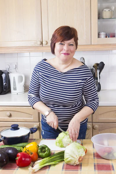 Edad media ama de casa cocinar verduras — Foto de Stock