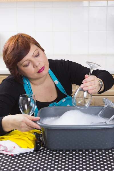 Smiling housewife cleaning wine glasses — Stock Photo, Image