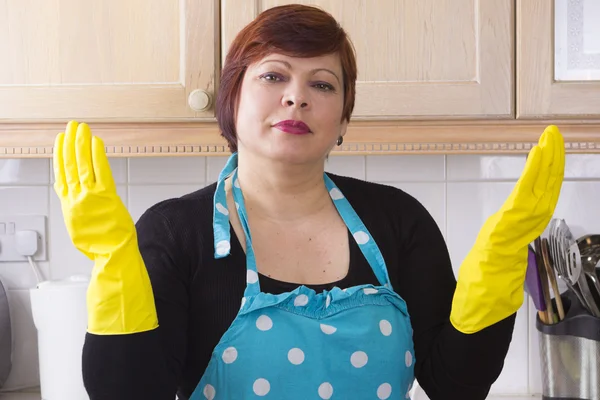 Женщина средних лет вытирает пыль на кухне — стоковое фото