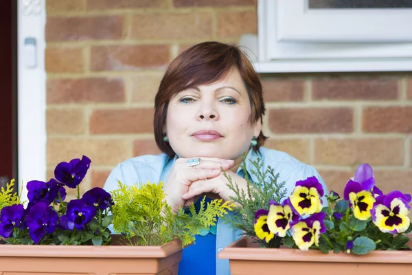 Lykkelig kvinne som slapper av på terrassen og smiler – stockfoto
