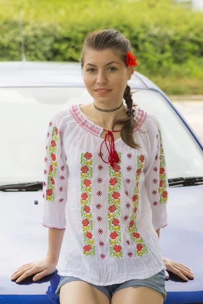 Fille en chemisier roumain près de la voiture — Photo