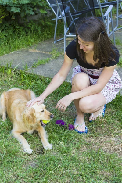 Linda chica acariciando perro al aire libre — Foto de Stock