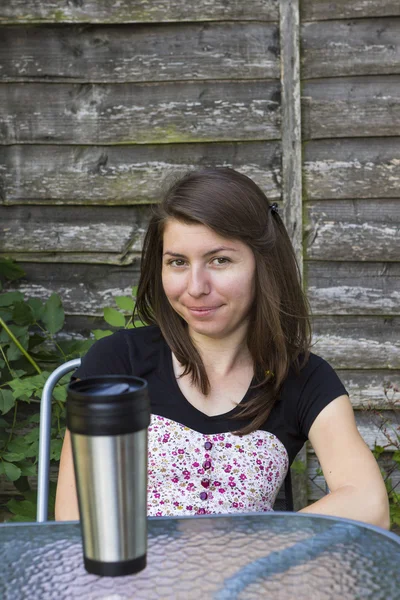 Jonge brunette koffie drinken in de tuin — Stockfoto