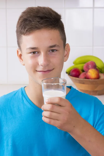 Chlapec se sklenicí mléka v kuchyni — Stock fotografie