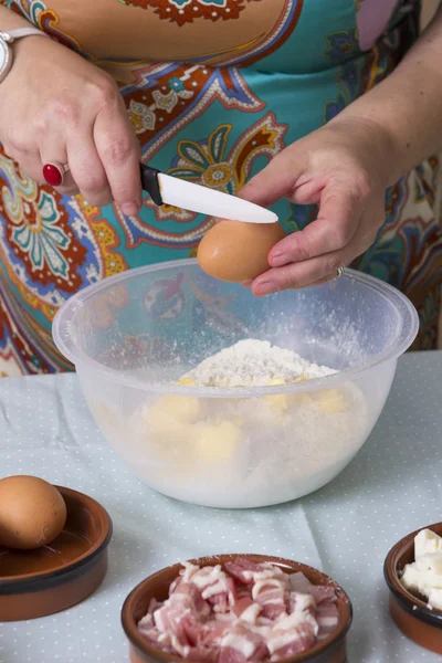 Donna matura che cuoce l'uovo in ciotola — Foto Stock