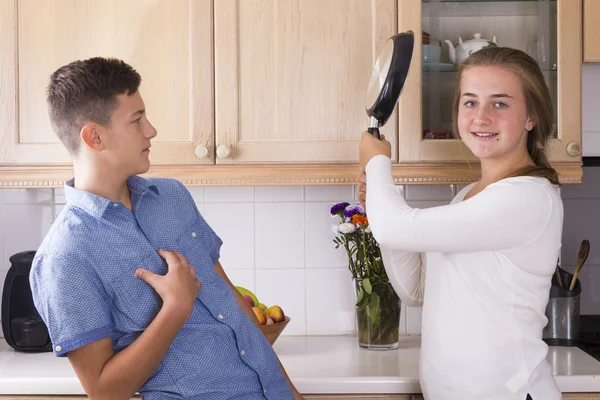 Los hermanos adolescentes que tienen lucha en la cocina — Foto de Stock