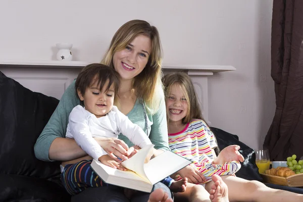 Mother reading to kids in bed — Stock Photo, Image