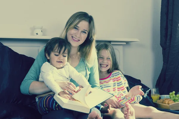 Mother reading to kids in bed — Stock Photo, Image