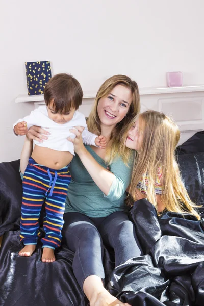 Family portrait in bed at home — Stock Photo, Image