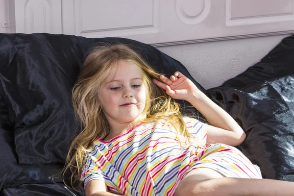 Klein meisje liggend in bed thuis — Stockfoto