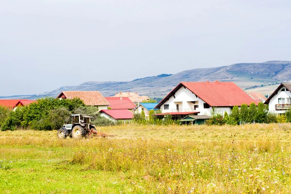 Rural summer landscape with tractor and cottages — Stock Photo, Image