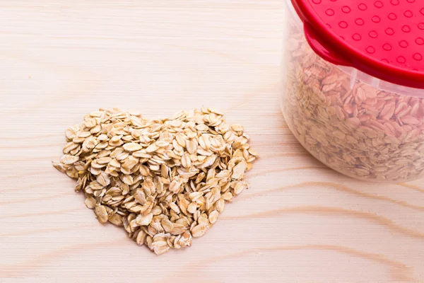 Heart-shaped oatmeal on wooden background — Stock Photo, Image