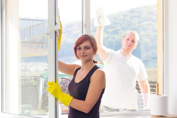 Giovane coppia spolverare finestre a casa — Foto Stock