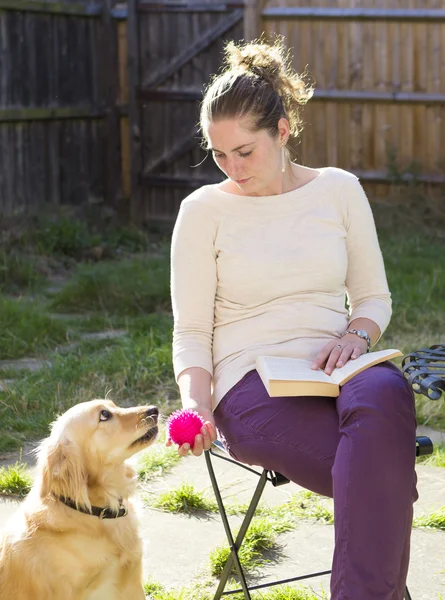 Linda chica jugando con perro al aire libre — Foto de Stock