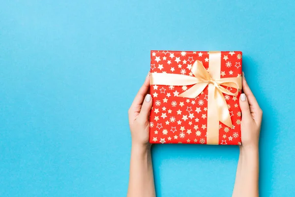 Brazos Mujer Sosteniendo Caja Regalo Con Cinta Color Sobre Fondo —  Fotos de Stock