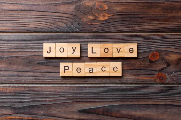 joy love peace word written on wood block. joy love peace text on cement table for your desing, concept.