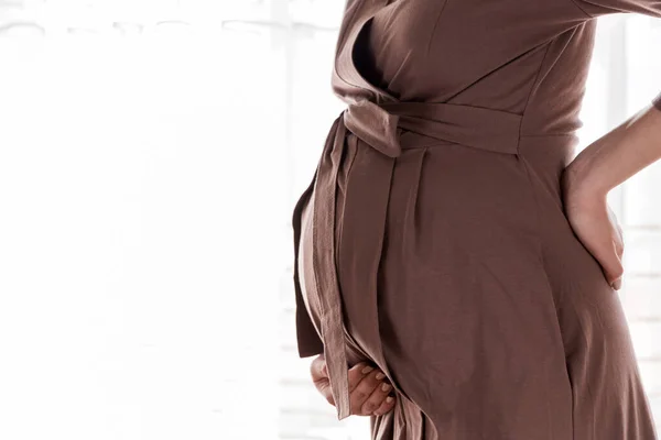 怀孕的母亲站在窗边 在卧室里摸她的背 怀孕保健概念 — 图库照片