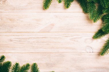 Ahşap zemin üzerinde köknar ağacı dallarından yapılmış çerçevenin üst görüntüsü. Tasarımınız için boş boşluklu Noel kavramı.