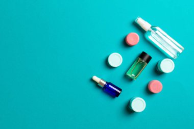 Kozmetik SPA marka modeli, fotokopi alanı olan üst görünüm. Renkli arka planda duran krema tüpleri ve kavanozları..