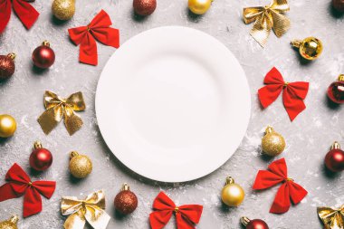 Çimento arka planındaki bayram yemeğinin en üst görüntüsü. Tabak, takılar ve fiyonklar. Noel Arifesi konsepti.