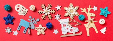 Kırmızı Noel arka planında bayram oyuncakları ve dekorasyonlarının afişi. Kopya alanı ile Yeni Yıl konsepti.