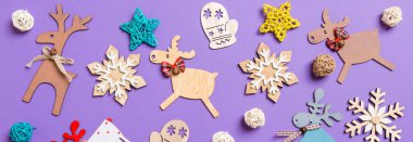 Banner Festivali dekorasyonları ve mor arka planda oyuncaklar. Mutlu Noeller..