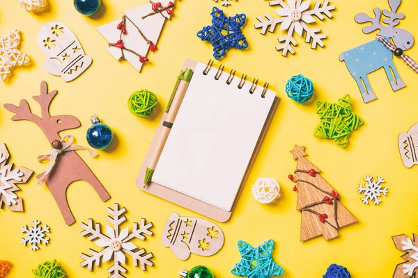 Bovenaanzicht Van Notebook Gele Achtergrond Met Nieuwjaarsspeelgoed Decoraties Kerstconcept — Stockfoto