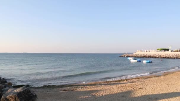 Морские волны, разбивающиеся на песчаном пляже и создающие белую воду в солнечное лето — стоковое видео