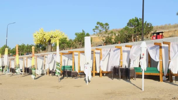 Άδεια παραλία στην ακτή ενός παραθαλάσσιου θέρετρου. Μοναχικές ξαπλώστρες και κοντινές ομπρέλες. Resort οφείλεται σε covid 2019, coronavirus — Αρχείο Βίντεο