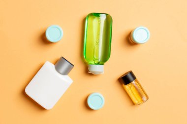 Kozmetik SPA marka modeli, fotokopi alanı olan üst görünüm. Renkli arka planda duran krema tüpleri ve kavanozları..