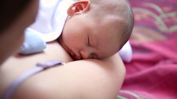 Little baby boy sleeping on moms chest outdoor. mother hugging sleeping baby in her arms and kissing the kid gently — Stock Video