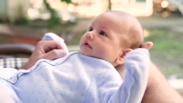 Les parents jouent avec le nouveau-né petit enfant le tenant dans leurs bras gros plan — Video