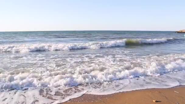 Onde marine che si infrangono su una spiaggia di sabbia e creano acqua bianca in un'estate soleggiata — Video Stock