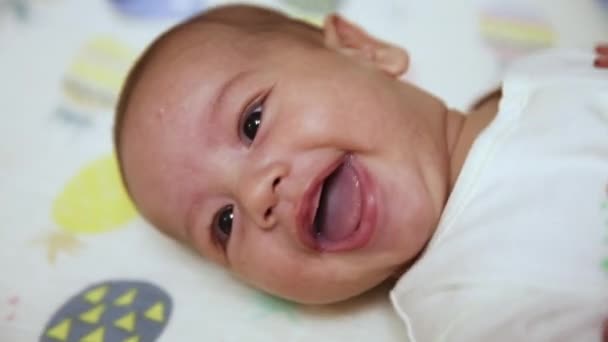 Un pequeño bebé recién nacido caucásico es divertido sonriendo, Retrato de un niño juguetón y enérgico de cerca — Vídeo de stock