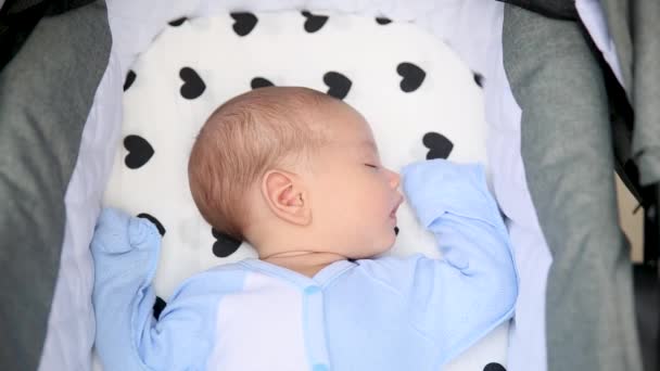 Gros plan portrait extérieur de petit garçon dans le sommeil doux dans la poussette — Video